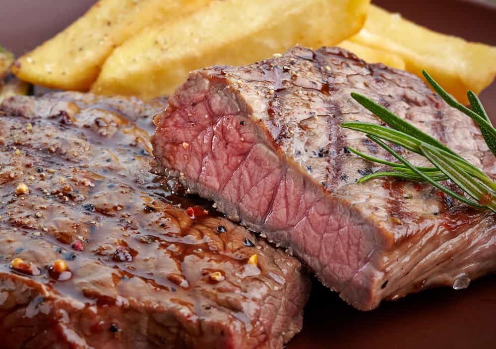 grilled beef steak on wooden cutting board